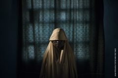 Aisha, age 14, stands for a portrait in Maiduguri, Borno State, Nigeria on Sept. 21, 2017. Aisha was kidnapped by Boko Haram then assigned a suicide bombing mission. After she was strapped with explosives, she found help instead of blowing herself and others up. Photo by Adam Ferguson for The New York Times